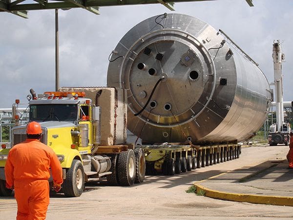 A large metal object being transported by truck.