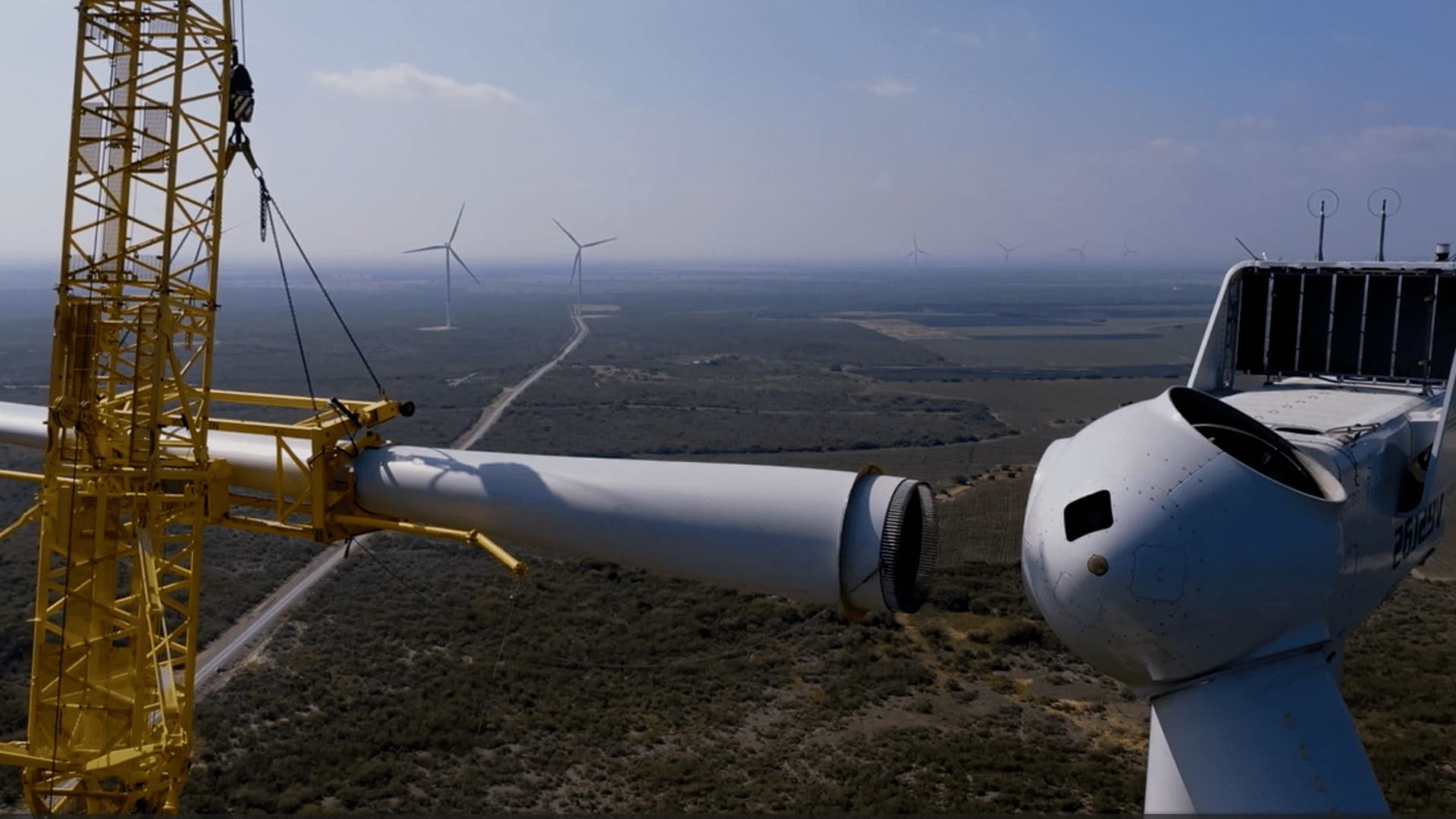 A wind turbine is being pulled by a crane.